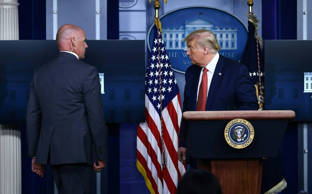 US President Donald Trump is being removed by a member of the secret service from the Brady Briefing Room of the White House in Washington, DC.