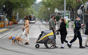 People walk their dogs in Melbourne on 30 September 2021 as the city grapples with a surge in Covid-19 infections.
