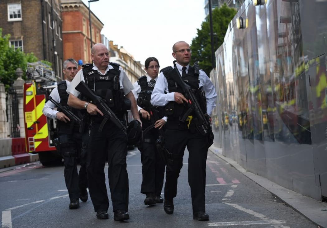 Armed police officers patrol the streets from Borough Market towards The Shard in London.