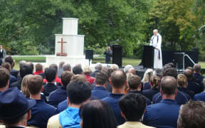 People listening to memorial service at the Botanical Gardens.