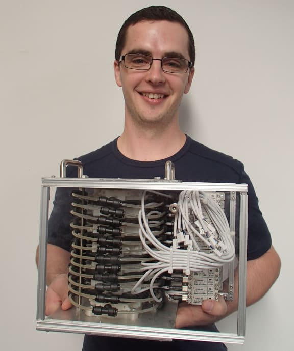 Steven Dirven holds a small box containing the swallowing robot.