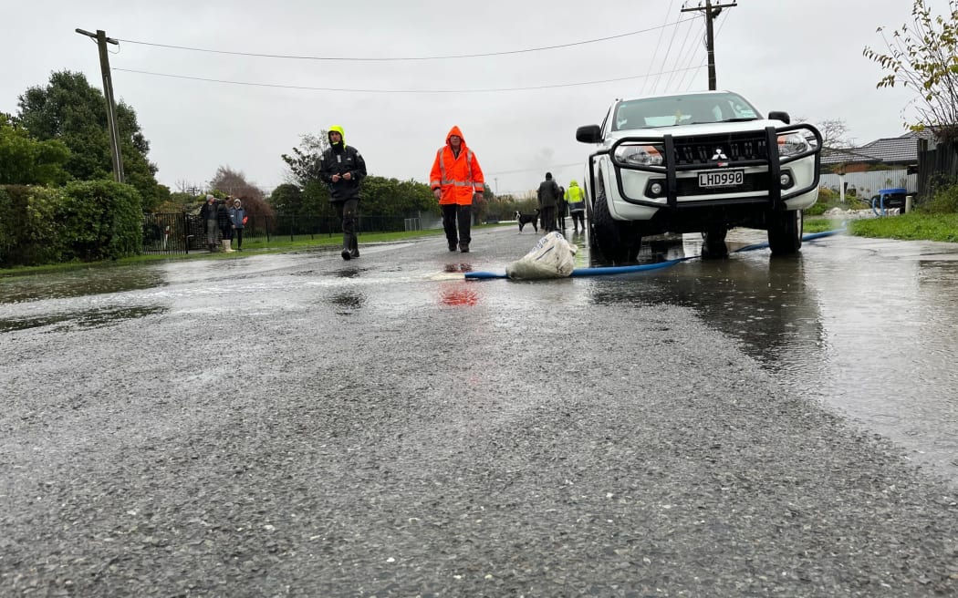A Hathaway Street resident trying to clear water from his property with a water pump.