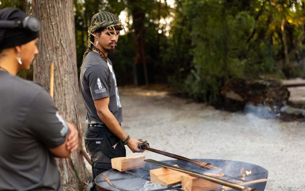 Graduates Kingi Aupouri and Tawhiri Solomon tempering their taiaha.