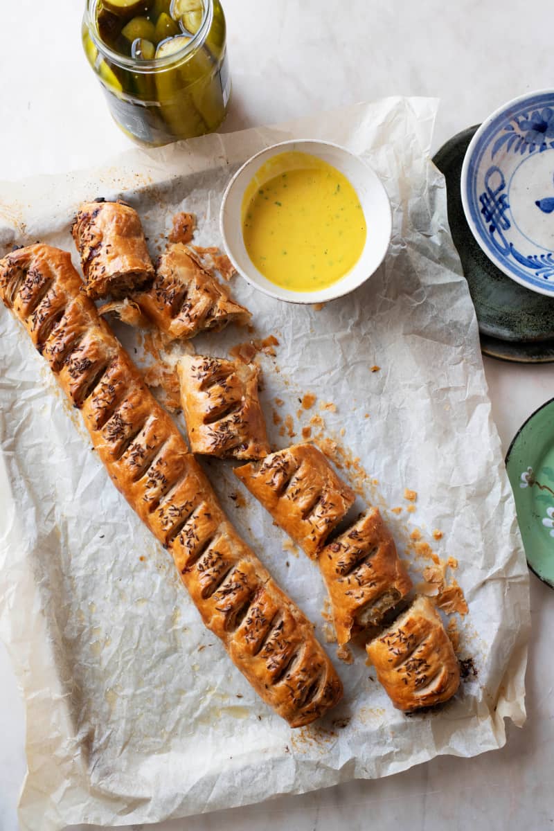 Two long sausage rolls on baking paper.