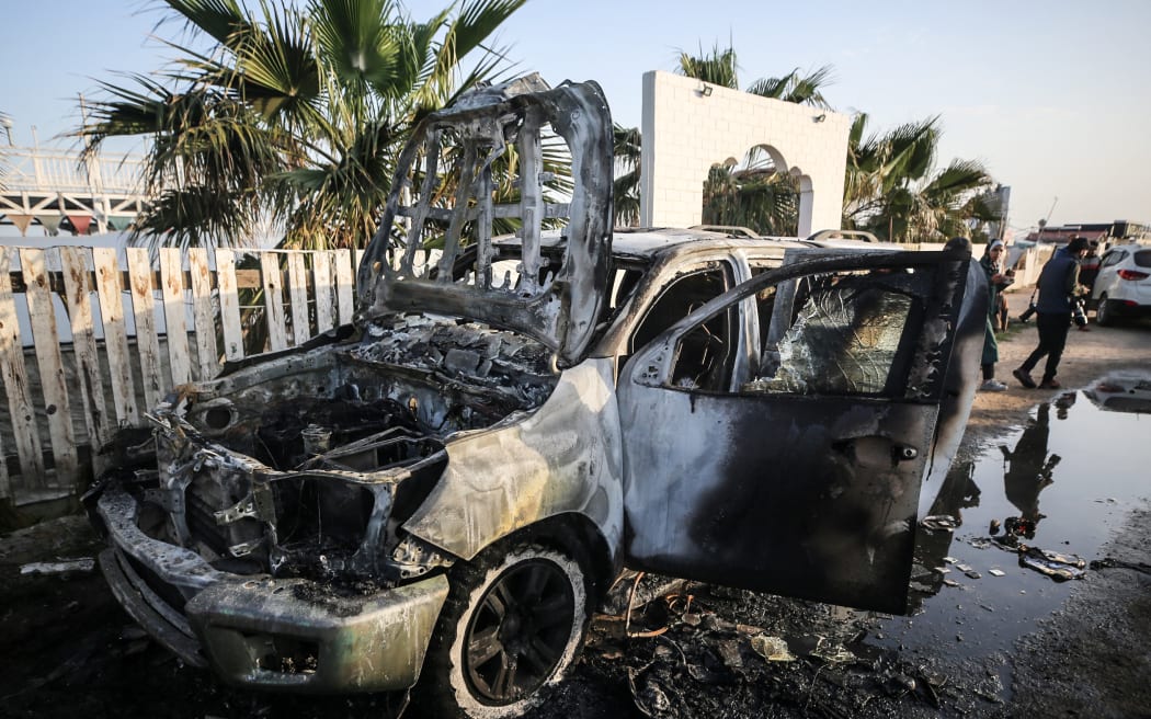 Palestinians are standing next to a vehicle in Deir Al-Balah, in the central Gaza Strip, on April 2, 2024, where employees from the World Central Kitchen (WCK), including foreigners, were killed in an Israeli airstrike, according to the NGO. The Israeli military is stating that it is conducting a thorough review at the highest levels to understand the circumstances of this ''tragic'' incident, amid the ongoing conflict between Israel and Hamas. (Photo by Majdi Fathi/NurPhoto) (Photo by MAJDI FATHI / NurPhoto / NurPhoto via AFP)