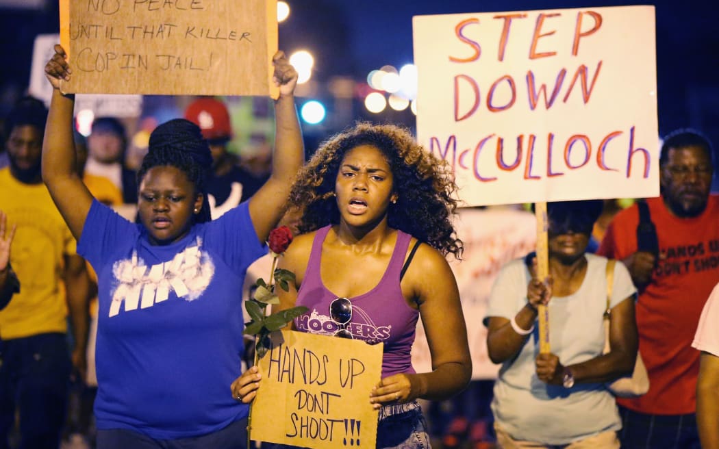 Demonstrators protest the death of Michael Brown on 21 August 2014 in Ferguson, Missouri.