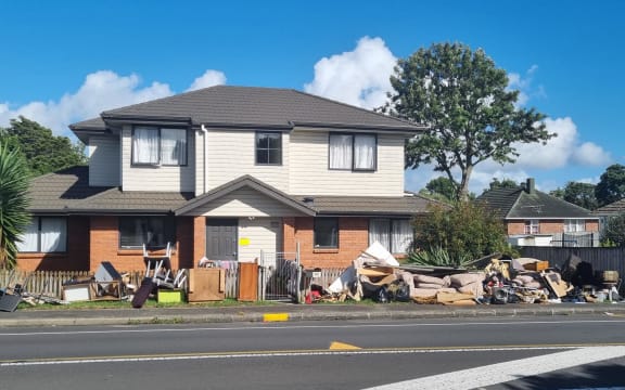 Debris is seen piled up outside a house in the Auckland suburb of Mt Roskill following the Auckland floods of January 2023.