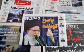 Daily Iranian newspapers are fronted with the image of Iran's Supreme Leader Ayatollah Ali Khamenei and other headlines,  displayed at a kiosk in Tehran on February 18, 2026. Iran said February 17, 2026, it had agreed with the United States in talks in Geneva on "guiding principles" for a deal to avoid conflict, but the US Vice President said Tehran had not yet acknowledged all of Washington's red lines. (Photo by ATTA KENARE / AFP)