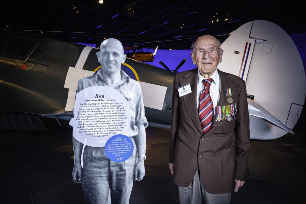 Ron Hermanns standing with a cut-out figure of his younger self at the Air Force Museum of New Zealand in 2019.