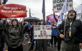 Flight attendants protest in front of the Air Canada headquarters near Pierre-Elliott Trudeau Airport in Montreal, Quebec, Canada, on August 17, 2025. Canadian transport minister Patty Hajdu called for binding arbitration and a return to work order that Air Canada said they would put into effect as of 2PM EST on August 17, 2025. However, the union representing Air Canada flight attendants said that they would contest the return to work order and will continue to strike. (Photo by ANDREJ IVANOV / AFP)