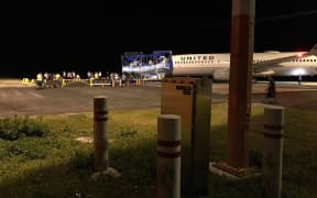 Passengers and crew on and around a grounded United Airlines flight at Amata Kabua International Airport in Majuro at 2:00am Thursday. They were refused entry because of a total ban on incoming travelers by air due to the spread of Covid-19 globally