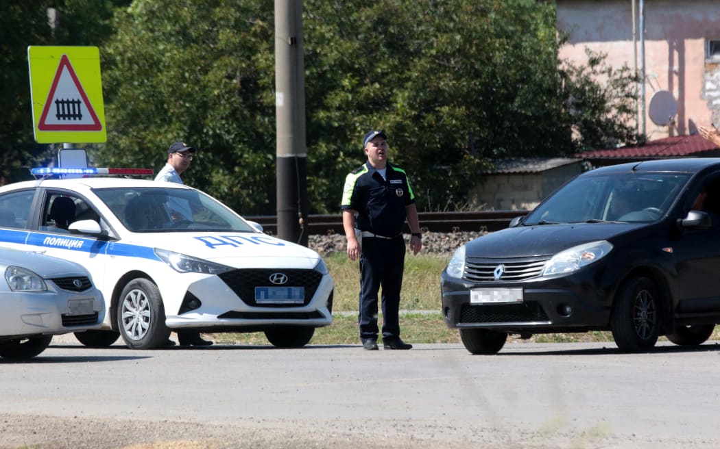 Traffic police officers block the road in the small town of Oktyabr'skoye near Simferopol, on July 22, 2023. A Ukrainian drone attack on Crimea on July 22 blew up an ammunition depot, sparking evacuations on the Moscow-annexed peninsula and halting rail traffic.
