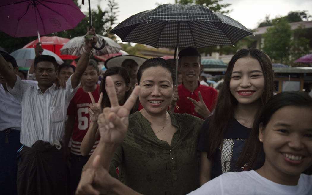 Supporters of Myanmar opposition leader Aung San Suu Kyi's party cheer outside the party headquarters in Yangon.