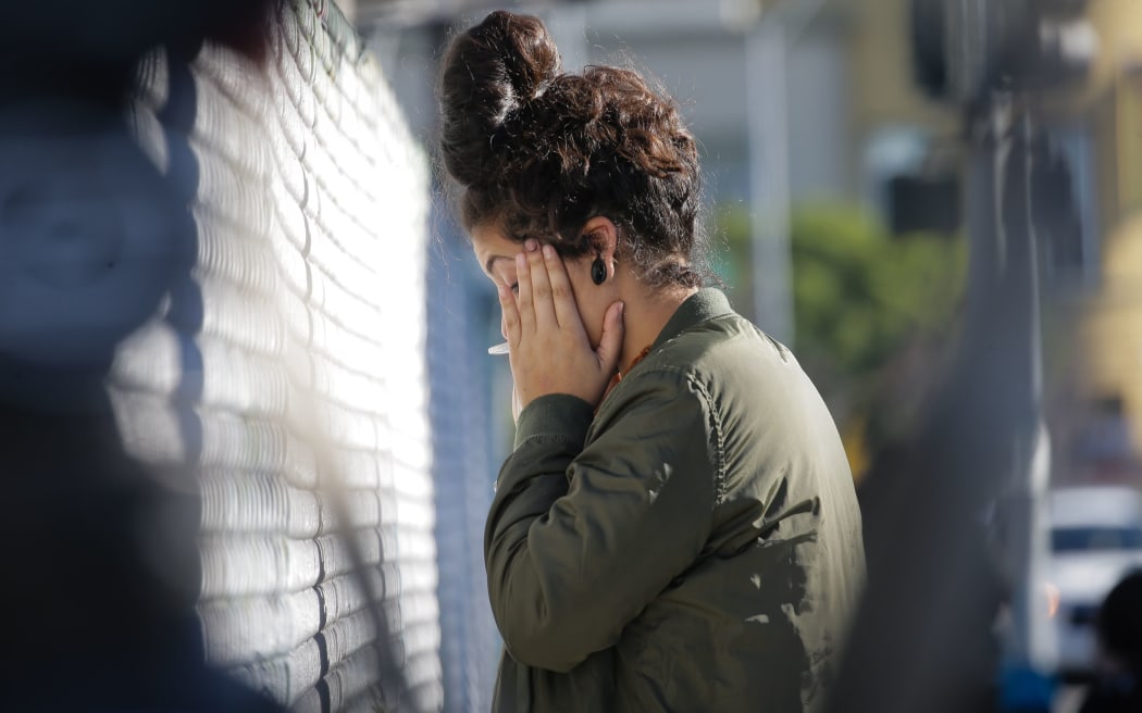 A woman becomes emotional while speaking on the phone near the scene following a fire at a warehouse in the Fruitvale neighborhood on December 3, 2016 in Oakland, California.