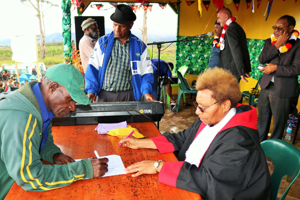 Kopolga ward councillor, Michael Namba, signing the agreement in front of Mt Hagen Principal Magistrate, Betty Jacob