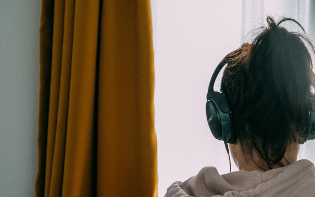 woman with headphones and grey hoodie