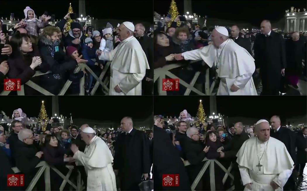 January 1, 2020 frame grabs taken from a handout video made available by Vatican Media shows a lady with her hands clasped as she watches Pope Francis arrive to celebrate New Year's Eve mass in Vatican City