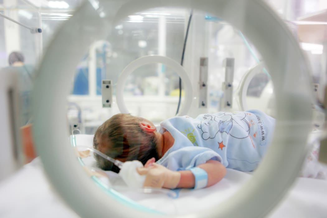 Newborn baby in hospital. Baby care unit.