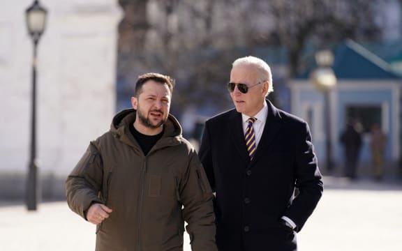 US President Joe Biden (R) walks next to Ukrainian President Volodymyr Zelensky (L) as he arrives for a visit in Kyiv on 20 February, 2023.,