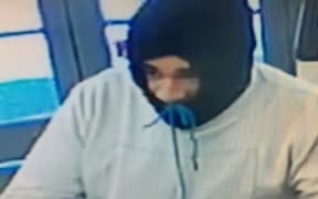 This man was wearing a grey sweat shirt with a dark coloured hood covering his face.