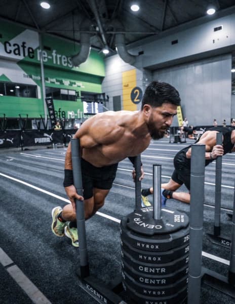 Abbas Nazari doing the sled push at a Hyrox competition.