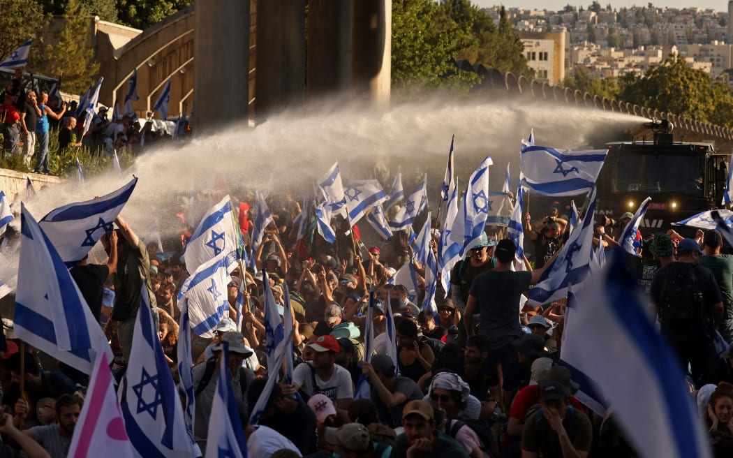 Israeli security forces use a water cannon to disperse demonstrators blocking the entrance of the Knesset, Israel's parliament, in Jerusalem on July 24, 2023, amid a months-long wave of protests against the government's planned judicial overhaul. Israeli lawmakers on July 24 prepared for a final vote on a major component of the hard-right government's controversial judicial reforms even as US President Joe Biden called for postponing the "divisive" bill that has triggered mass protests. (Photo by HAZEM BADER / AFP)
