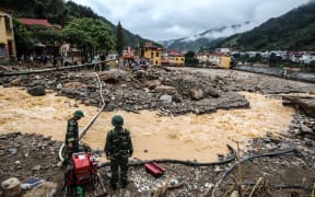 Soldiers operate a water pump amid destruction caused by flash floods in the mountainous town of Mu Cang Chai in the northern province of Yen Bai.