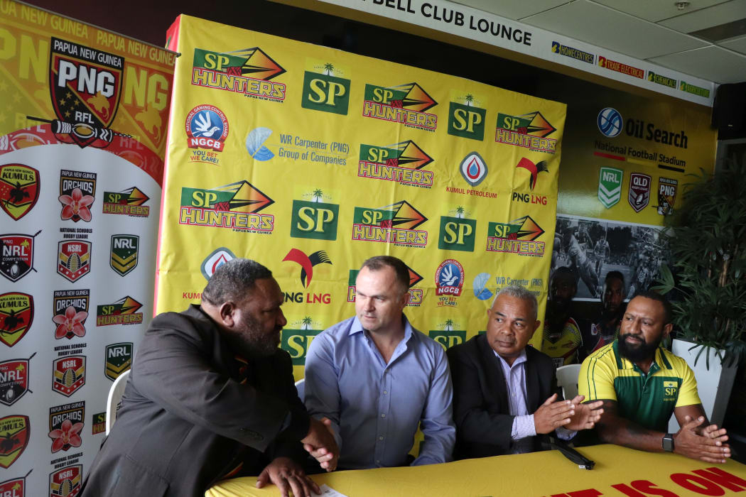 PNG Rugby League chairman Sandis Tsaka (L) shakes hands with new Papua New Guinea Hunters coach Matt Church.