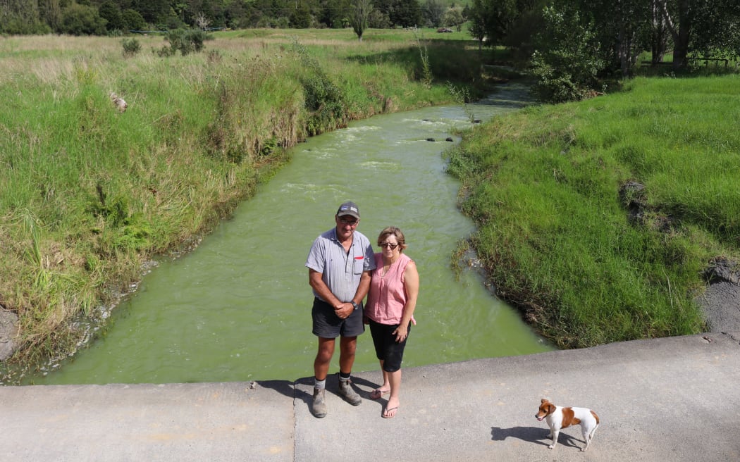 Utakura Valley landowners Neville and Linda Lewis during an algal bloom in 2018, which turned Lake Ōmāpere’s outflow bright green and killed large numbers of eels.