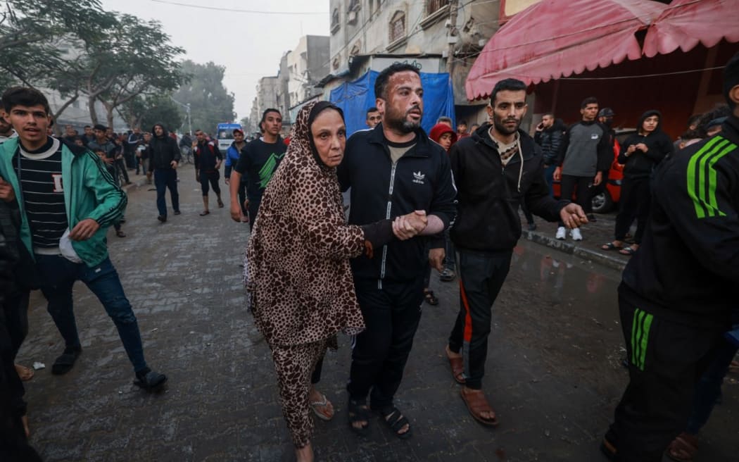 Palestinians react following Israeli bombardment in Rafah, in the southern Gaza Strip on December 12, 2023, amid ongoing battles between Israel and the Palestinian militant group Hamas. (Photo by MOHAMMED ABED / AFP)