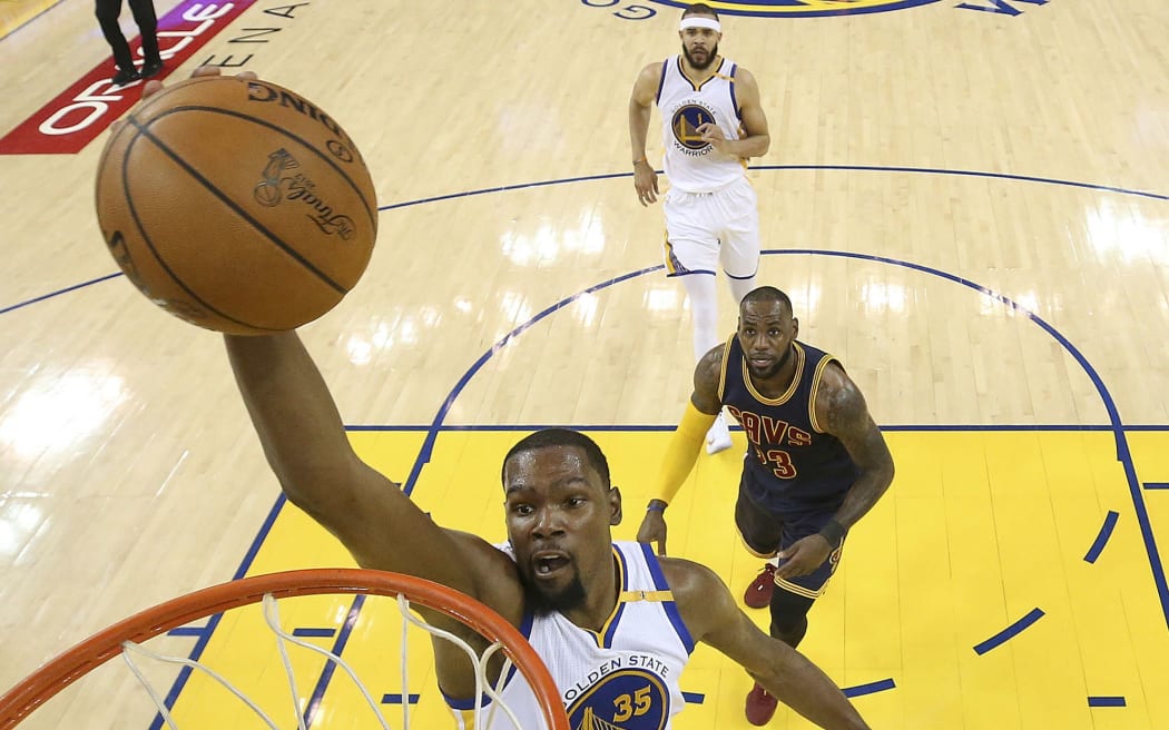 Golden State Warriors forward Kevin Durant dunks in front of Cleveland Cavaliers forward LeBron James