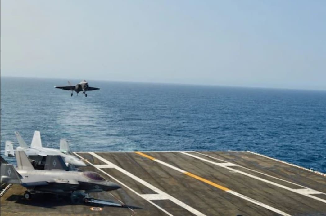 A US F35-C lightning II prepares to land on an aircraft carrier.