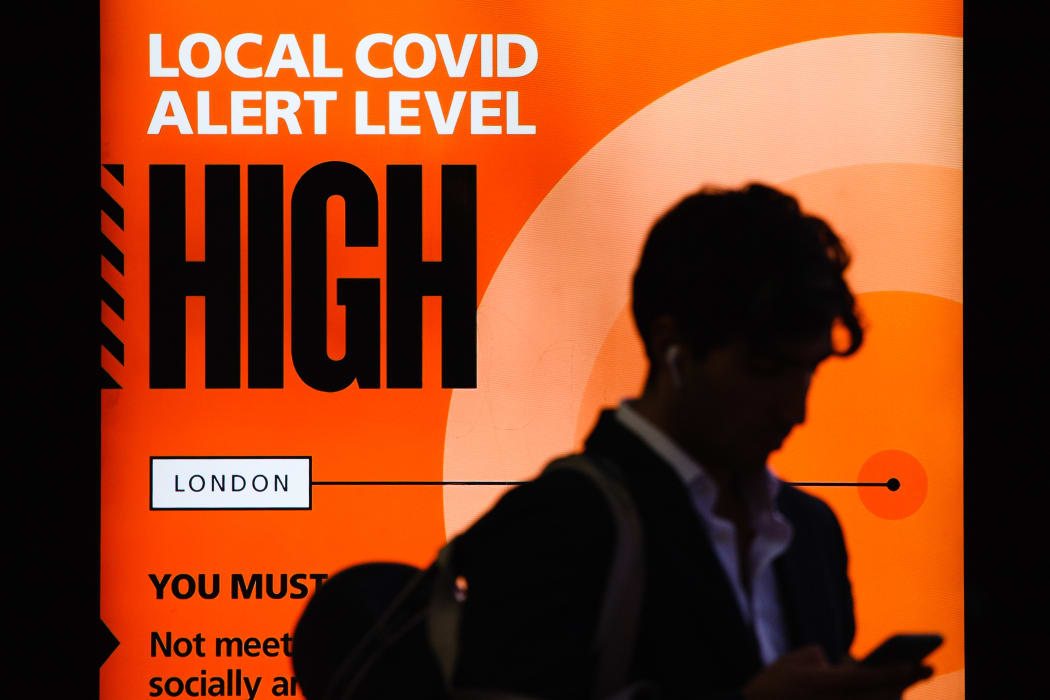 A government public information notice reminding people of 'High' (or 'Tier 2') coronavirus restrictions lights up the advertising panel of a bus stop on Knightsbridge in London, England/