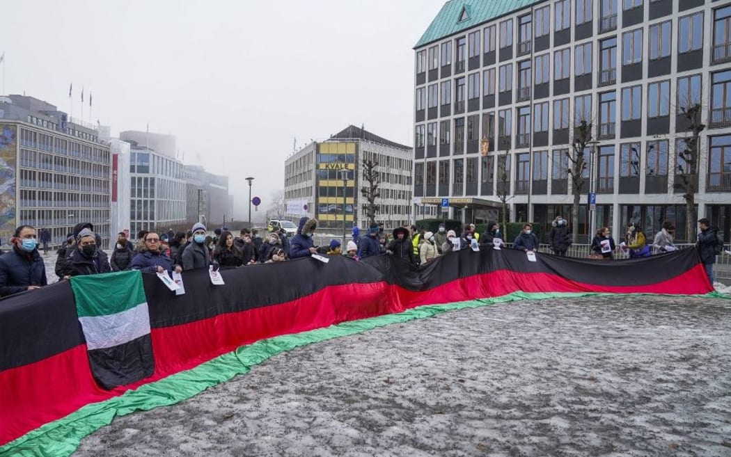 Protesters gather holding an Afghan flag outside the Ministry of Foreign Affairs in Oslo, Norway, on January 23, 2022, after the Taliban delegation arrived for talks.