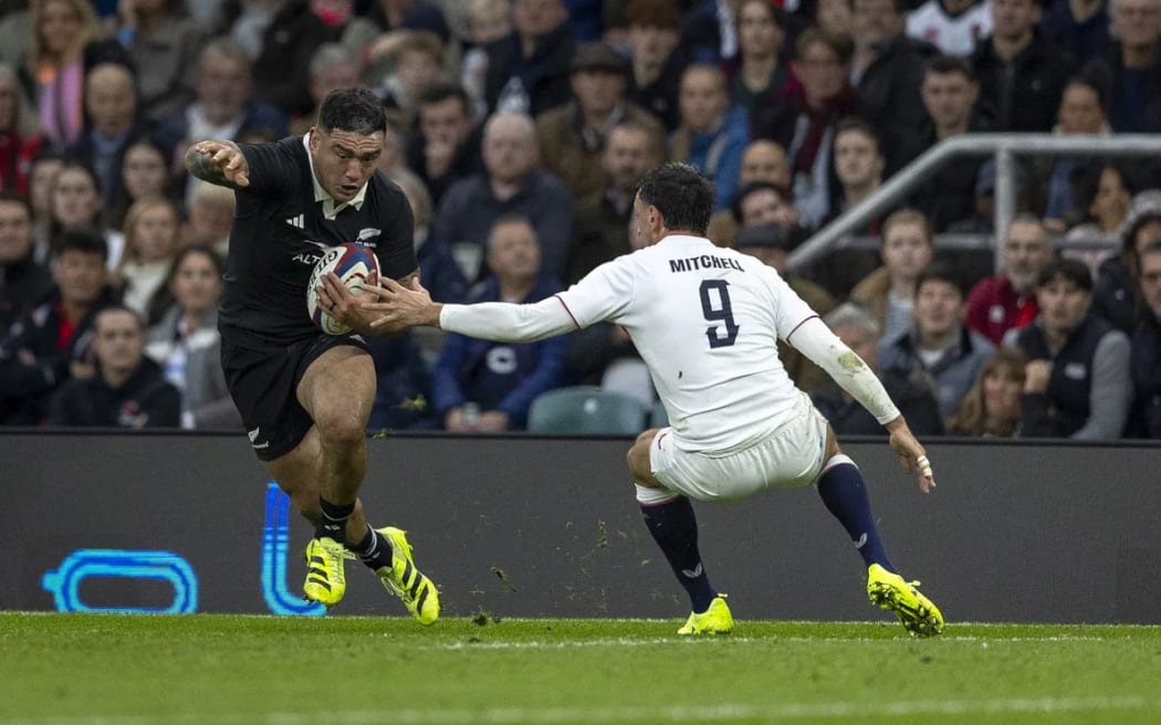 Codie Taylor runs the ball past Alex Mitchell of England during the England v All Blacks match, Allianz Stadium, Twickenham.