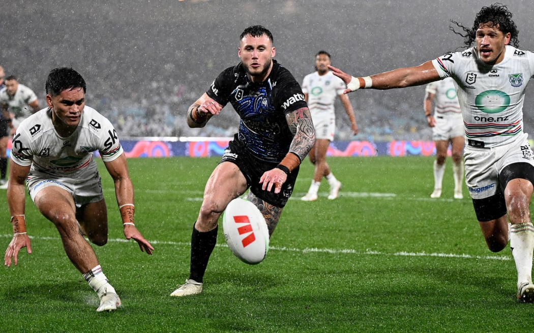 Bronson Xerri of the Bulldogs contests for the ball with Taine Tuaupiki (left) and Dallin Watene-Zelezniak of the Warriors.