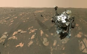 This NASA photo shows the Perseverance Mars rover in a selfie with the Ingenuity helicopter, seen here about 13 feet (3.9 meters) from the rover, on April 6, 2021, the 46th Martian day, or sol, of the mission and taken by the WATSON (Wide Angle Topographic Sensor for Operations and eNgineering) camera. NASA is targeting no earlier than Sunday, April 11, for Ingenuity Mars Helicopter’s first attempt at powered, controlled flight on another planet. A livestream confirming Ingenuity’s first flight is targeted to begin around 3:30 a.m. EDT Monday, April 12.