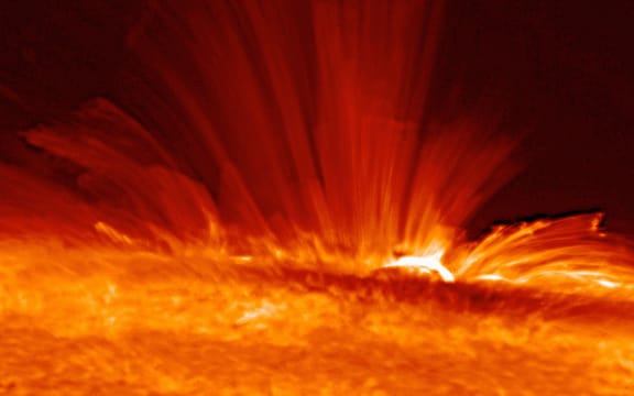 Sunspot with streamers of super-hot, electrically charged gas (plasma) arc from the surface of the Sun, revealing the structure of the solar magnetic field.