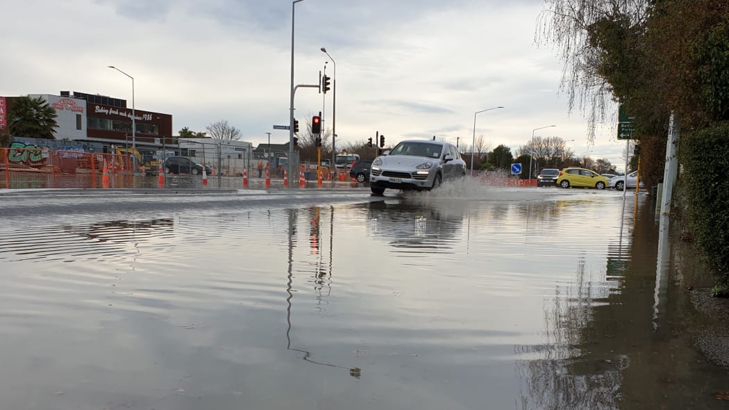 A car travels through floodwater on Innes Rd, Christchurch after a blown watermain.