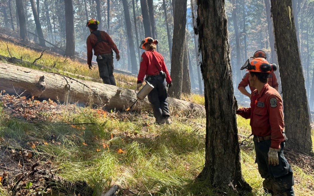 Firefighters deal with hotspots in Canadian fire.
