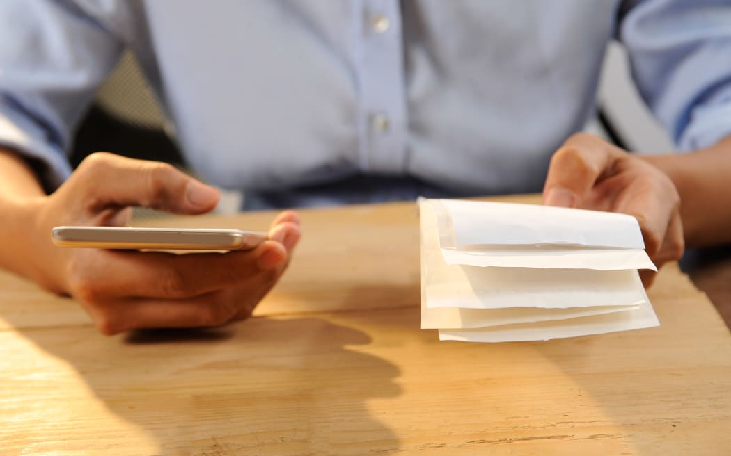 Closeup of person calculating or paying bills. Woman using smartphone. Online payment concept. Cropped view.