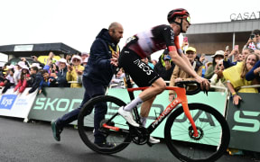INEOS Grenadiers team's Dutch rider Thymen Arensman is assisted after crossing the finish line after winning the 14th stage of the 112th edition of the Tour de France cycling race, 182.6 km between Pau and Luchon-Superbagneres, in the Pyrenees mountains of southwestern France, on July 19, 2025. (Photo by Marco BERTORELLO / AFP)