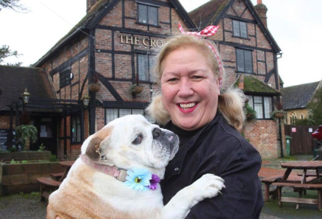 Christchurch born landlady, Vanda Perry stands in fron of the Crown Inn that she runs in the village of Capel in Surry holding her English bulldog. Gladys