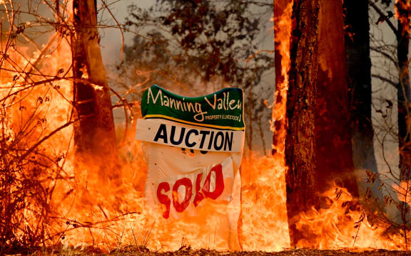 A bushfire burns outside a property near Taree, 350km north of Sydney on November 12, 2019.