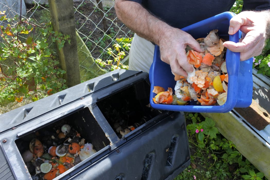 Man emptying a container full of domestic food waste, ready to be composted.
