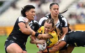 Tamika Upton of Australia tackled by Gayle Broughton of New Zealand and Angelina Teakaraanga-Katoa of New Zealand.