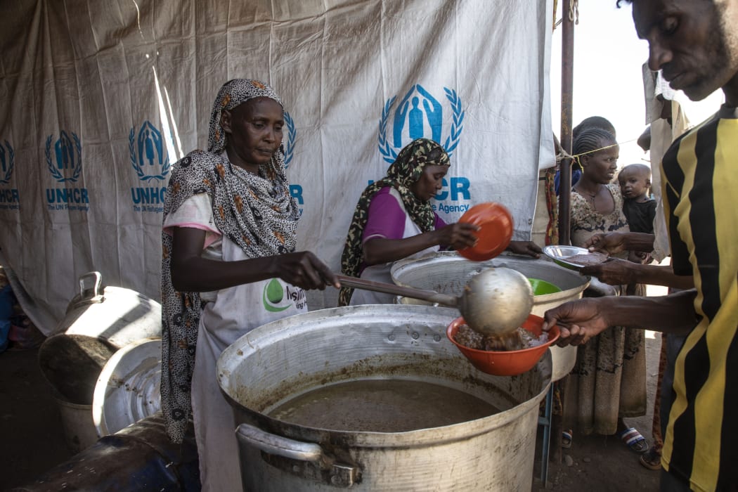 Ethiopians, who fled the conflict in the Tigray region in northern Ethiopia, receive food at Hamdayit area after reaching Kassala State, Sudan on 14 December, 2020.