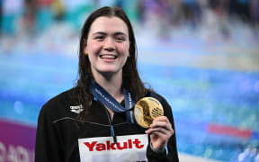 New Zealand's Erika Fairweather poses with her gold medal on the podium of the women's 400m freestyle swimming event during the 2024 World Aquatics Championships at Aspire Dome in Doha on February 11, 2024. (Photo by SEBASTIEN BOZON / AFP)