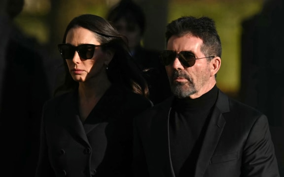 Simon Cowell (R) and Lauren Silverman leave after attending the funeral service of the late One Direction singer Liam Payne, at St Mary's church in Amersham, west of London on November 20, 2024. - The funeral of former One Direction singer Liam Payne who died last month after falling from his Buenos Aires hotel room was held on Wednesday. (Photo by JUSTIN TALLIS / AFP)