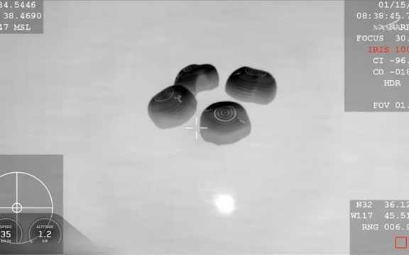 The SpaceX Dragon capsule carrying the Crew-11 astronauts is seen from a night-vision camera on board an aircraft in the moments before splashdown. NASA